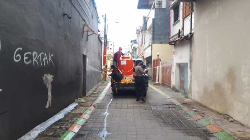 Bhabinkamtibmas Melayu Baru Dampingi PMI Penyemprotan Disinfektan di Pemukiman Warga