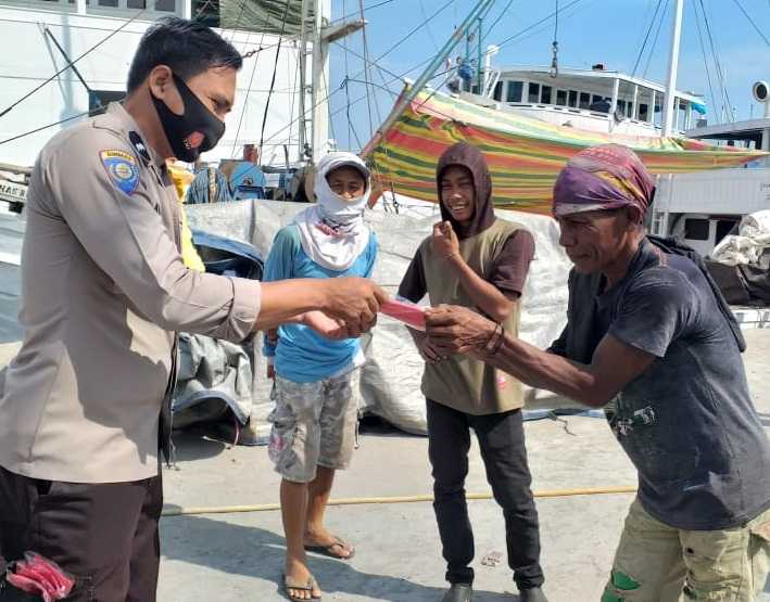 Bhabinkamtibmas Gusung Bagikan Masker ke Masyarakat