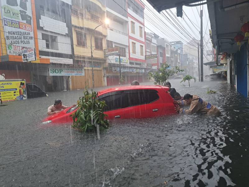 Aksi Heroik Bhabinkamtibmas Melayu Baru Bantu Dorong Mobil Mogok Terjebak Banjir