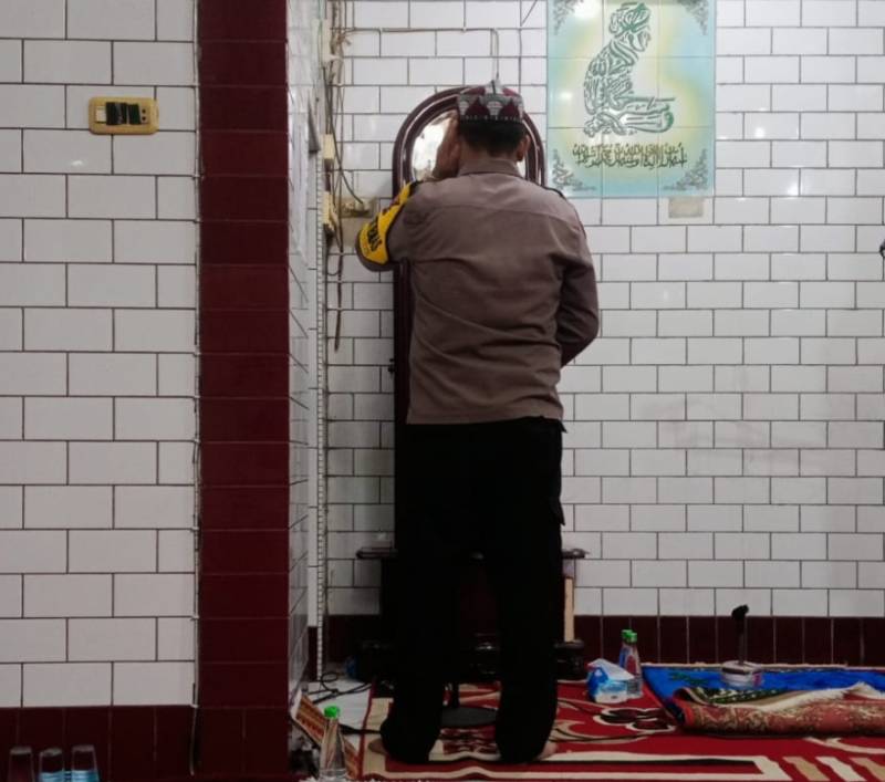 Sambil Pengamanan Masjid, Bhabinkamtibmas Patingalloang Baru Mengumandangkan Azan Salat Isha