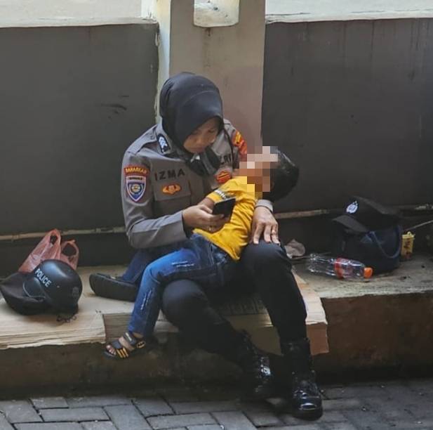 Kisah Seorang Polwan Membawa Anak Saat Bertugas Pengamanan Eksekusi 